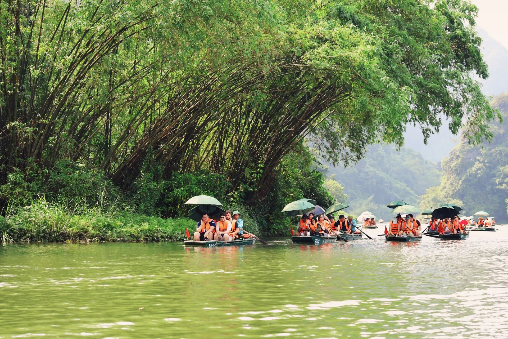 Enjoying a scenic boat tour through limestone valleys is the ultimate highlight of a day trip from Hanoi to Ninh Binh